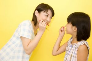 娘に歯の磨き方を教える母親
