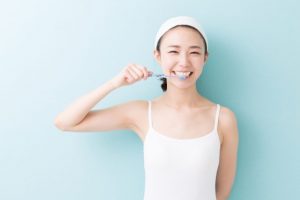 笑顔で歯を磨く女性