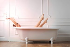 お風呂に入りながら、脚と手を伸ばしている女性