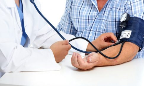 患者の血圧を図っている医者
