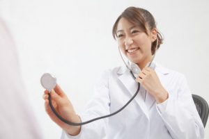 聴診器を当てようとしている女性医者