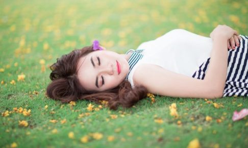 芝生の上で寝ている女性